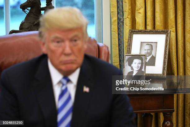 Framed photographs of U.S. President Donald Trump's parents, Fred and Mary Trump, sit on a table in the Oval Office while the president meets with...