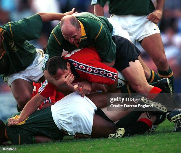 Gerhard Engelbreght of South Africa grabs the face of Nic Witkowski of Canada during their match at the I.R.B World Sevens Rugby series played at...