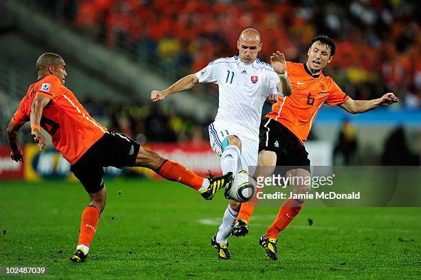 Robert Vittek of Slovakia is challenged by Nigel De Jong and Mark Van Bommel of the Netherlands during the 2010 FIFA World Cup South Africa Round of...