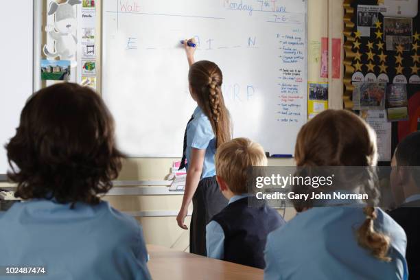 young student at front of class - englisch unterricht stock-fotos und bilder