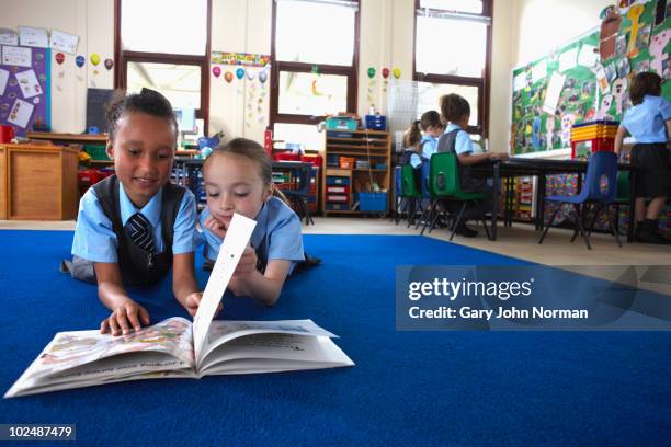 two young school children reading together - child reading book stock pictures, royalty-free photos & images