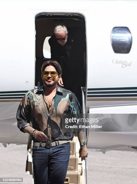 Singer Adam Lambert and drummer Roger Taylor of Queen + Adam Lambert get off a jet as they arrive at the MGM Resorts aviation hangar to kick off the...