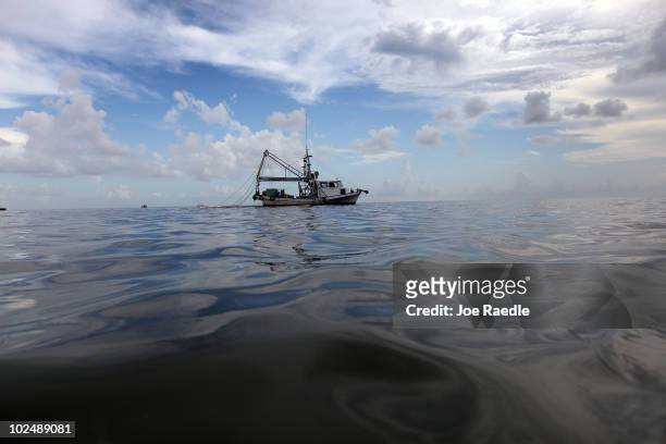 Boat uses a boom and absorbent material to soak up oil on the surface of the water from the Deepwater Horizon oil spill in the Gulf of Mexico in Cat...