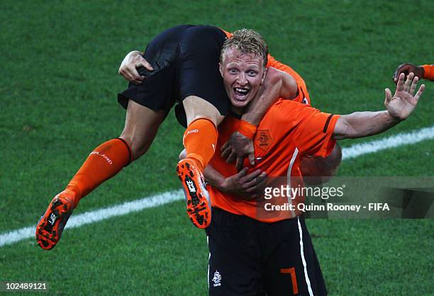 Dirk Kuyt of the Netherlands carries goalscorer Wesley Sneijder after he scores his side's second goal during the 2010 FIFA World Cup South Africa...