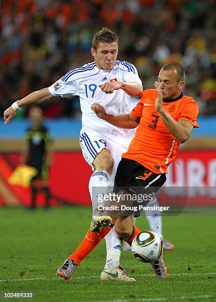 John Heitinga of the Netherlands challenges Juraj Kucka of Slovakia during the 2010 FIFA World Cup South Africa Round of Sixteen match between...