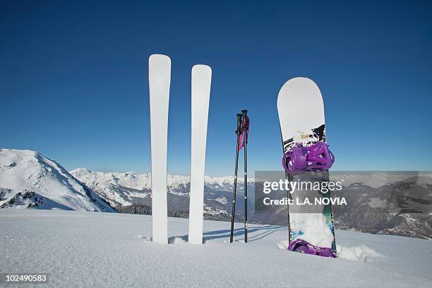 skis and snowboard stuck in the snow - prancha de snowboard - fotografias e filmes do acervo