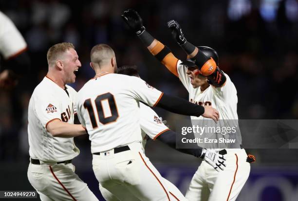 Gorkys Hernandez of the San Francisco Giants is congratulated by teammates after he hit a single that scored the game-winning run in the ninth inning...