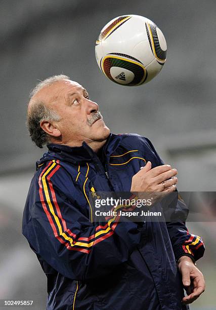 Head coach Vicente del Bosque of Spain bounces a ball on his shoulder during a training session, ahead of their 2010 World Cup Stage 2 Round of 16...