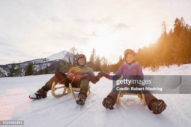 couple sledding on winter landscape - recreational equipment stock pictures, royalty-free photos & images