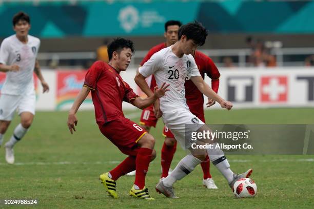 Kim Jungmin of South Korea battles Luong Xuan Truong of Vietnam during the Men's Footbal semi final competition between Vietnam and South Korea held...