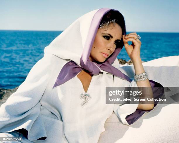 Actress Elizabeth Taylor wearing a white robe during the filming of 'The Sandpiper', 1965.