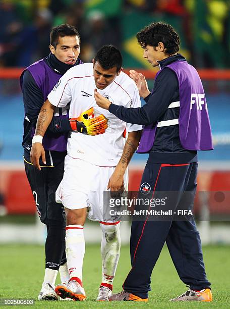 Arturo Vidal of Chile is comforted by teammate Miguel Pinto after the 2010 FIFA World Cup South Africa Round of Sixteen match between Brazil and...
