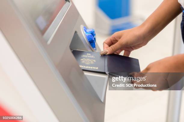 unrecognizable woman scans passport at airport kiosk - self service check in stock pictures, royalty-free photos & images