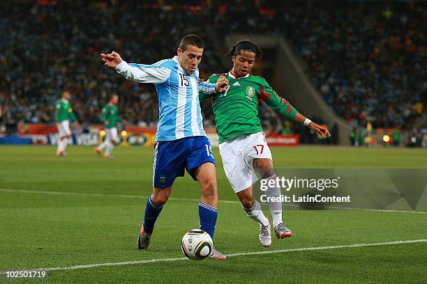 Giovani dos Santos of Mexico struggles for the ball with Nicolas Otamendi of Argentina during a match of 2010 FIFA World Cup at Soccer City Stadium...