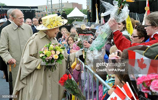 Queen Elizabeth II is presented with flowers on a walk-about at the Garrison on June 28, 2010 in Halifax, Canada. The Queen and Duke of Edinburgh are...