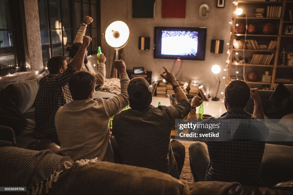Freunden verbringen Wochenende gemeinsam vor dem Fernseher