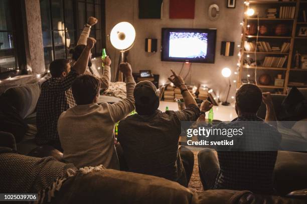 friends spend weekend together watching tv - american football sport stock pictures, royalty-free photos & images