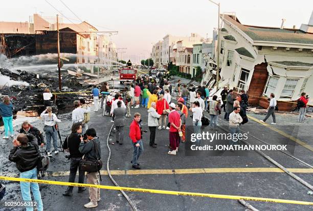 Firefighters extinguish fire in the Marina District in San Francisco 21 October 989 after a quake erupted 17 October in the city, killing an...