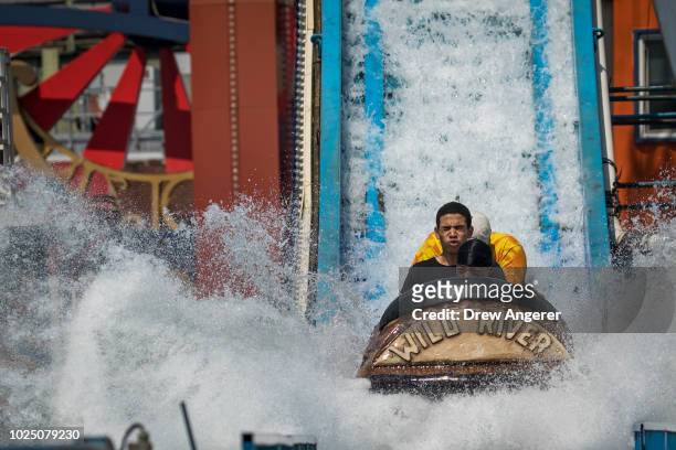 People ride a log flume ride at Luna Park on Coney Island, August 29, 2018 in the Brooklyn borough of New York City. The New York City area is under...