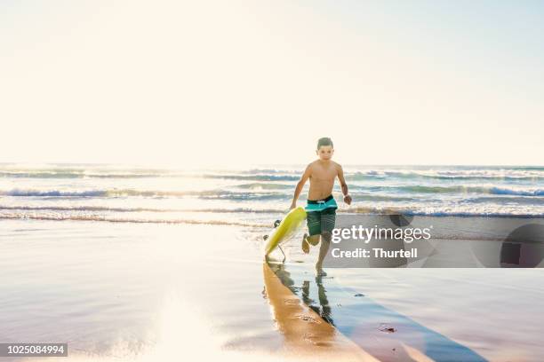 australian aboriginal boy at beach with surf rescue board - emergency services australia imagens e fotografias de stock