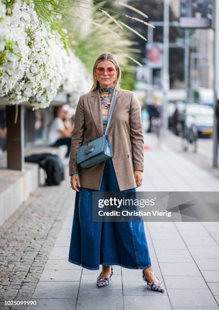 Janka Polliani wearing cropped wide leg denim jeans, brown blazer, blue Loewe bag seen during Stockholm Runway SS19 on August 29, 2018 in Stockholm,...