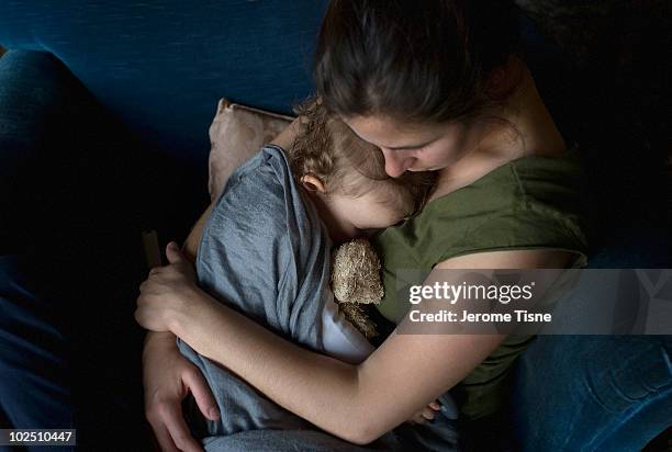 sleeping 18 months baby girl in mother's arms - tired mum stock pictures, royalty-free photos & images