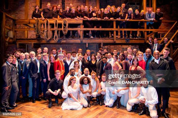 Britain's Prince Harry, Duke of Sussex, and Britain's Meghan, Duchess of Sussex pose with the cast and crew backstage after a gala performance of the...