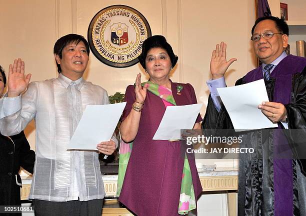 Supreme Court Associate Justice Diosdado Peralta admisters the oath of office on ex-Philippine first lady Imelda Marcos and her son, Ferdinand Marcos...