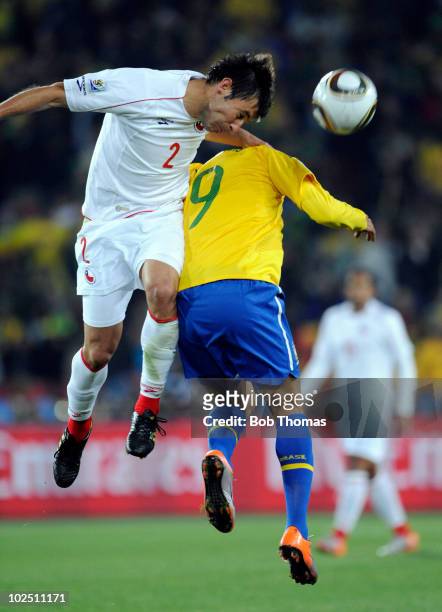 Ismael Fuentes of Chile heads the ball while challenged by Luis Fabiano of Brazil during the 2010 FIFA World Cup South Africa Round of Sixteen match...