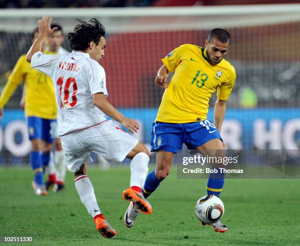 Dani Alves of Brazil challenged by Jorge Valdivia of Chile during the 2010 FIFA World Cup South Africa Round of Sixteen match between Brazil and...