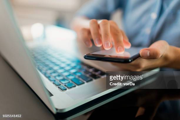 woman using a phone - laptop stock pictures, royalty-free photos & images