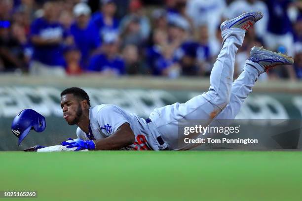 Yasiel Puig of the Los Angeles Dodgers dives into third base after hitting a triple against the Texas Rangers in the top of the seventh inning at...