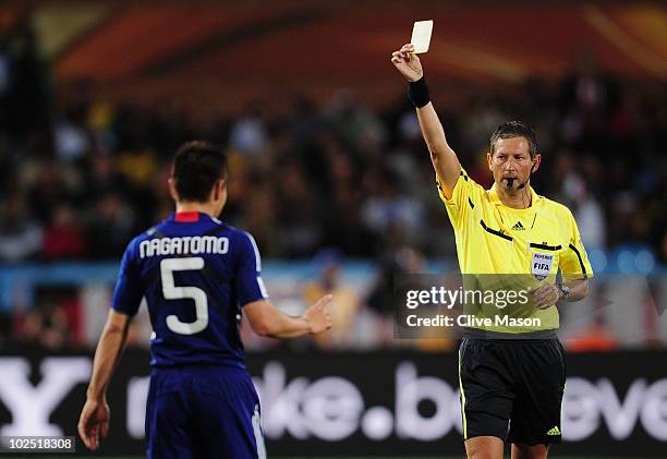 Yuto Nagatomo of Japan is shown a yellow card by Referee Frank de Bleeckere during the 2010 FIFA World Cup South Africa Round of Sixteen match...