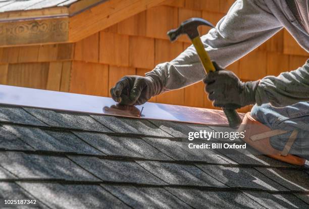 uomo che installa tetto in asfalto - costruttore di tetti foto e immagini stock