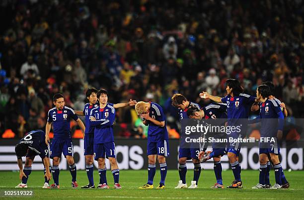 The Japan team cant bear to watch as penalties are taken during extra time in the 2010 FIFA World Cup South Africa Round of Sixteen match between...