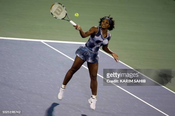 Serena Williams of the US returns the ball to Italy's Sara Errani during their singles tennis match on the third day of the WTA Dubai Tennis...