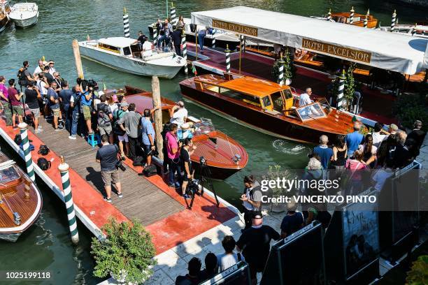 Photographers and festival goers gather at a pier were actors arrive by boat at the Excelsior hotel on August 30, 2018 during the 75th Venice Film...