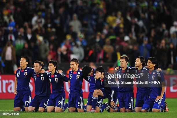 The Japan team kneel and watch on as penalities are taken during the 2010 FIFA World Cup South Africa Round of Sixteen match between Paraguay and...