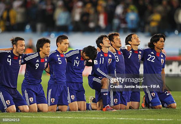 The Japan team kneel and watch on as penalities are taken during the 2010 FIFA World Cup South Africa Round of Sixteen match between Paraguay and...