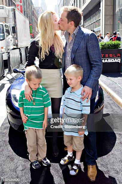 Elon Musk, chairman and chief executive officer of Tesla Motors, kisses his fiancee Talulah Riley as they stand with Musk's twin boys Griffin, left,...
