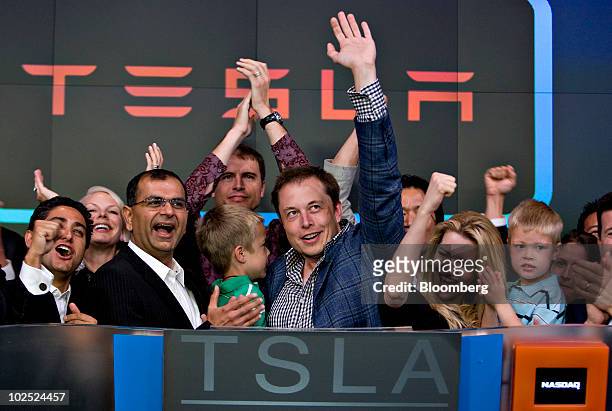Elon Musk, chairman and chief executive officer of Tesla Motors, center, participates in the opening bell ceremony at the Nasdaq Marketsite with his...