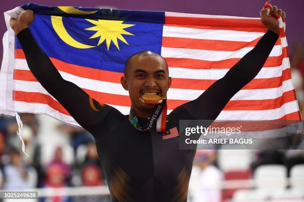 Gold medallist Malaysia's Mohd Azizulhasni Awang celebrates during the awards ceremony for the men's sprint event of the cycling track competition at...