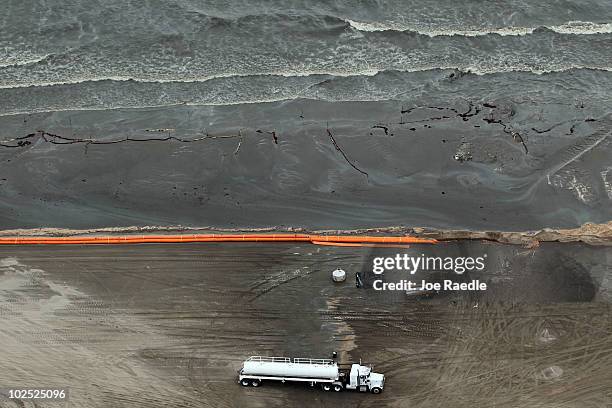 Oily absorbent material along with containment booms are seen placed on the beach as efforts to clean the beach from effects of the Deepwater Horizon...