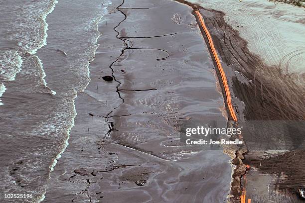 Oily absorbent material along with containment booms are seen placed on the beach as efforts to clean the beach from effects of the Deepwater Horizon...