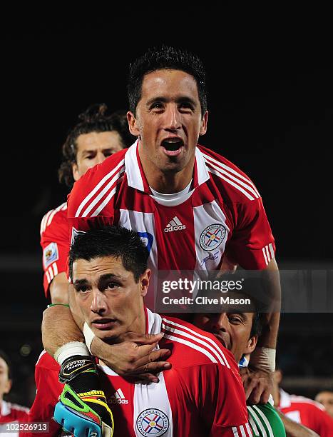 Oscar Cardozo of Paraguay celebrates with team mate Lucas Barrios after scoring his penalty as his team win a penalty shoot-out during the 2010 FIFA...
