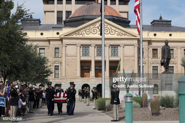 Military honor guard carry the casket of U.S. Sen. John McCain from the Arizona State Capitol to go to a memorial service at the North Phoenix...