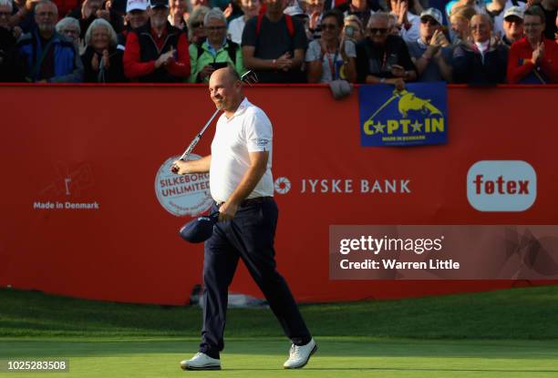 Thomas Bjorn walks on the 18th as the crowd hold up signs showing he is the captain for the european team for the ryder cup during day one of the...