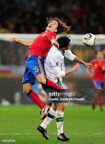 Carles Puyol of Spain and Hugo Almeida of Portugal jump for the ball during the 2010 FIFA World Cup South Africa Round of Sixteen match between Spain...