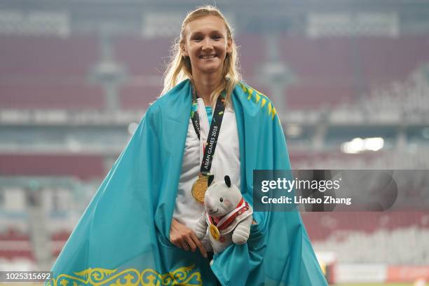 Gold medallist Olga Rypakova of Kazakhstan celebrates during the medal ceremony for the women's triple jump on day twelve of the Asian Games on...