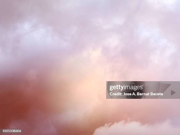 full frame of the low angle view of clouds of colors in sky during sunset with crepuscular light. valencian community, spain - atmosphere clouds stock pictures, royalty-free photos & images